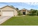 Tan house with a two car garage and lush lawn at 3570 Manor Loop, Lakeland, FL 33810