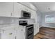 Modern kitchen features white cabinets, stainless steel appliances, and marble countertops at 3570 Manor Loop, Lakeland, FL 33810