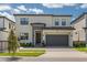 Two-story modern home with gray garage door and stone accents at 5773 High Seas Dr, Orlando, FL 32821