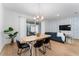 Bright dining area with light wood table and four black chairs, near the living room at 4683 Terrasonesta Dr, Davenport, FL 33837
