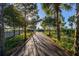Wooden boardwalk path through lush greenery towards the lake at 1402 Westminster Way, Kissimmee, FL 34744