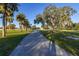 Paved pathway winds through a lush park with palm trees at 1402 Westminster Way, Kissimmee, FL 34744