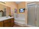 Bathroom with a large bathtub, shower, and wood vanity at 1402 Westminster Way, Kissimmee, FL 34744
