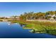 Scenic view of a calm lake with a park and lush vegetation at 1402 Westminster Way, Kissimmee, FL 34744