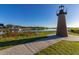 Brick lighthouse overlooking a calm lake with a pier and lush greenery at 1402 Westminster Way, Kissimmee, FL 34744