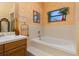 Bathroom with a large bathtub, shower, and wood vanity at 1402 Westminster Way, Kissimmee, FL 34744