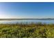 Scenic view of a calm lake with lush vegetation at 1402 Westminster Way, Kissimmee, FL 34744