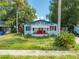 1920s bungalow with red door and overgrown yard at 1015 Ohio Ave, Saint Cloud, FL 34769