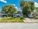 Charming single-story home with a red door, palm trees, and a spacious front yard at 1015 Ohio Ave, Saint Cloud, FL 34769