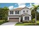 Two story home with beige siding, stone accents, and a two car garage at 4227 Sawtooth Ct, Tavares, FL 32778