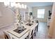 Bright dining room with a glass-top table and modern chandelier at 2505 Dharma Cir, Kissimmee, FL 34746