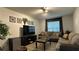 Living room with sectional sofa, large TV, and coffee table at 8860 Candy Palm Rd, Kissimmee, FL 34747