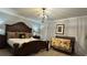 Main bedroom with a king-size bed, crib, and decorative lighting at 8860 Candy Palm Rd, Kissimmee, FL 34747