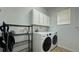 Bright laundry room with washer, dryer, and storage cabinets at 8860 Candy Palm Rd, Kissimmee, FL 34747