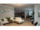 Open concept living area showcasing a white sectional sofa and kitchen view at 8860 Candy Palm Rd, Kissimmee, FL 34747