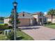 Exterior view of a charming one-story home with stone accents and a brick paver driveway at 678 Irvine Ranch Rd, Kissimmee, FL 34759