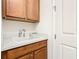 Laundry room with wooden cabinets, utility sink, and ample storage at 678 Irvine Ranch Rd, Kissimmee, FL 34759