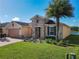 Exterior view of a house with a two-car garage, stone accents, and a nicely landscaped yard at 678 Irvine Ranch Rd, Kissimmee, FL 34759