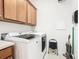 Bright laundry room with washer, dryer, and overhead storage at 678 Irvine Ranch Rd, Kissimmee, FL 34759