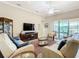 Spacious living room with multiple seating areas, a large TV, and access to a screened lanai at 678 Irvine Ranch Rd, Kissimmee, FL 34759