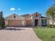 Exterior view of a single-story home with a two-car garage and beautifully landscaped yard at 678 Irvine Ranch Rd, Kissimmee, FL 34759