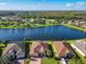 Aerial view showcasing three houses near a lake, highlighting the community setting at 678 Irvine Ranch Rd, Kissimmee, FL 34759