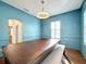 Elegant dining room features a large wood table, blue walls, and plantation shutters at 307 Norfolk St, Celebration, FL 34747