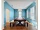 Elegant dining room features a large wood table, blue walls, and plantation shutters at 307 Norfolk St, Celebration, FL 34747