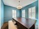 Elegant dining room features a large wood table, blue walls, and plantation shutters at 307 Norfolk St, Celebration, FL 34747