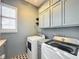 Laundry room with modern washer, dryer, and upper cabinets at 307 Norfolk St, Celebration, FL 34747