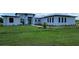 Modern, single-story home with a light-colored exterior and a large, grassy yard at 3612 Hidden River Ln, Tavares, FL 32778