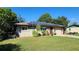 Tan brick home with solar panels and a well-manicured lawn at 112 10Th St, St Cloud, FL 34769