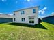 Two story home with sliding glass doors leading to a grassy backyard at 1823 Veterans Dr, Kissimmee, FL 34744