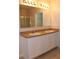 Double vanity bathroom with granite countertop and a large mirror at 1823 Veterans Dr, Kissimmee, FL 34744