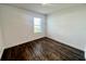 Bright bedroom with dark brown wood-look flooring and a window at 1823 Veterans Dr, Kissimmee, FL 34744