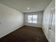 Spacious bedroom with brown carpet, large window, and neutral walls at 1823 Veterans Dr, Kissimmee, FL 34744