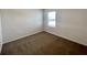 Well-lit bedroom featuring dark brown carpet and a window with blinds at 1823 Veterans Dr, Kissimmee, FL 34744