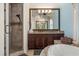 Modern bathroom with a walk-in shower, double vanity, and large mirror at 7435 Gathering Ct, Reunion, FL 34747