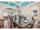 Elegant dining room with a large glass table and chandelier, offering a view of the kitchen and Gathering room at 7435 Gathering Ct, Reunion, FL 34747