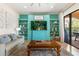 Gathering room with teal feature wall, built-in shelving, comfortable seating, and access to a patio at 7435 Gathering Ct, Reunion, FL 34747