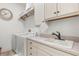Bright laundry room with washer, dryer, and additional storage at 7435 Gathering Ct, Reunion, FL 34747
