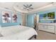 Relaxing main bedroom with light blue walls, a comfortable bed, and a large dresser at 7435 Gathering Ct, Reunion, FL 34747