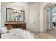 Spa-like bathroom with a large soaking tub, double vanity, and plenty of storage at 7435 Gathering Ct, Reunion, FL 34747