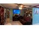 Living room with brown leather sofa and large TV at 2440 Summerfield Way, Kissimmee, FL 34741