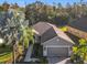 Single-story house with a gray exterior, paver driveway and walkway, surrounded by palm trees at 100 Vizcaya Ct, Kissimmee, FL 34759