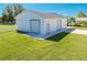 Detached white workshop with two garage doors and a side door at 2780 Vickie Ct, Kissimmee, FL 34744