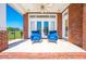 Brick patio with two blue chairs and French doors leading inside at 2780 Vickie Ct, Kissimmee, FL 34744