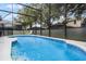 Inviting screened-in pool with tiled deck and safety fence at 8457 Secret Key Cv, Kissimmee, FL 34747