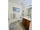Well-lit bathroom with shower, toilet and vanity with wood cabinets at 2280 San Vital Dr # 105, Kissimmee, FL 34741