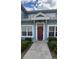 Inviting exterior of a light blue building with a red door and well-manicured landscaping at 2280 San Vital Dr # 105, Kissimmee, FL 34741